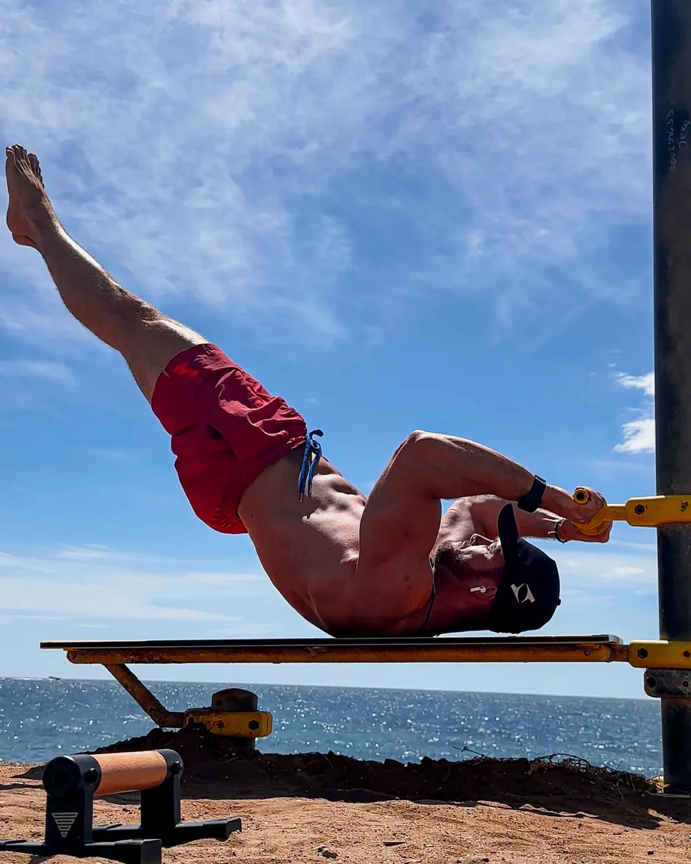 Philip Dingeldey bei einer Calisthenics-Übung an Parallettes am Meer